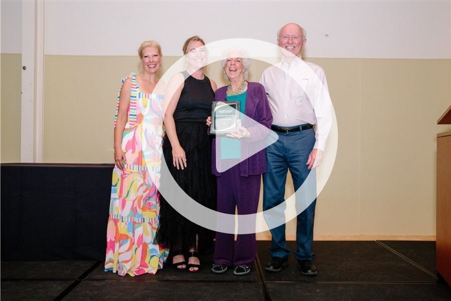 Pam & Jim accepting award with a play sign over it